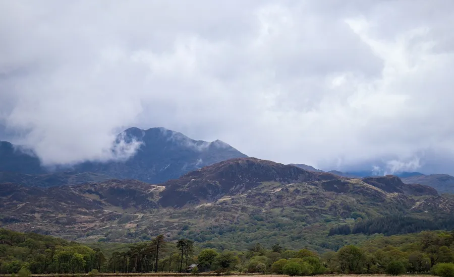 Cloud-wrapped mountain peaks rising above a green valley, the kind of Black Mountain view Tycroes looks out on